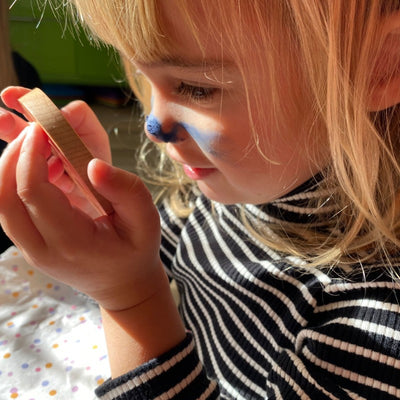 A girl using Ivy & Loulou natural play makeup butterfly blue